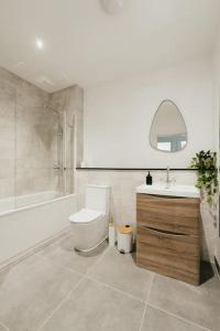 a bathroom with a toilet and a sink and a tub at Dawn House - Wyndale Living -Bham JQ 3BR Townhouse in Birmingham