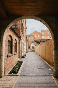 a brick alley with an archway in a building at Dawn House - Wyndale Living -Bham JQ 3BR Townhouse in Birmingham