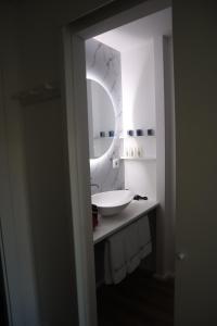 La salle de bains est pourvue d'un lavabo blanc et d'un miroir. dans l'établissement Refugio D Alecrim, à Paredes
