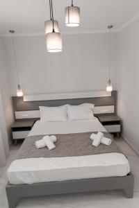 a bedroom with a large bed with two white towels at Flonikos Apartmnets in Tsimándria