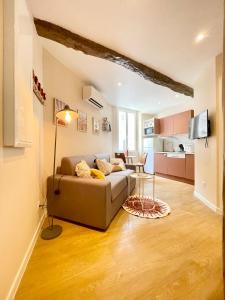 ein Wohnzimmer mit einem Sofa und einem Tisch in der Unterkunft Cosy & Chill Appartements - Au cœur du village de Cotignac, en Provence in Cotignac