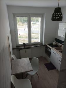 a kitchen with a table and chairs and a window at Apartament Azyl in Toruń