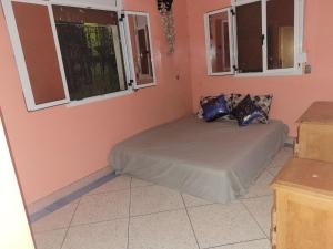 een slaapkamer met een bed in een roze kamer met ramen bij khenifra in Khenifra