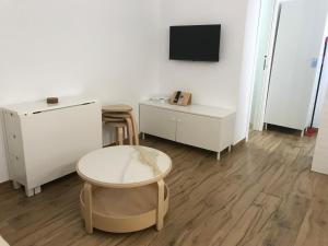 une pièce blanche avec une chaise, une table et une télévision dans l'établissement Casa Jaro, à Barbate