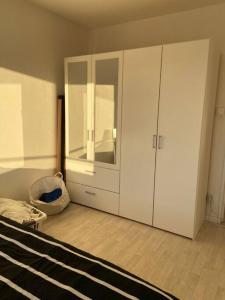 1 dormitorio con armario blanco y cama en F2 65m2 parking privé avec une belle vue, en Metz