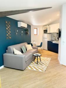 ein Wohnzimmer mit einem Sofa und einer Küche in der Unterkunft Cosy & Chill Appartements - Au cœur du village de Cotignac, en Provence in Cotignac