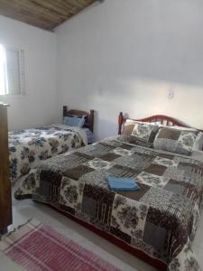 a bedroom with a bed with a quilt on it at Chale 8A in Cunha