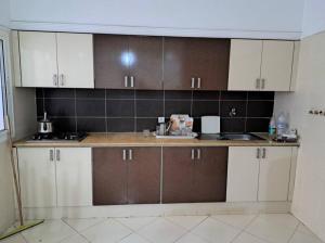 cocina con armarios marrones y blancos en una habitación en Apartment familiale oued laou, en Oued Laou