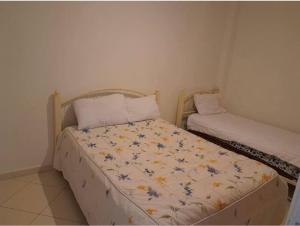 1 dormitorio pequeño con 2 camas en una habitación en Apartment familiale oued laou, en Oued Laou