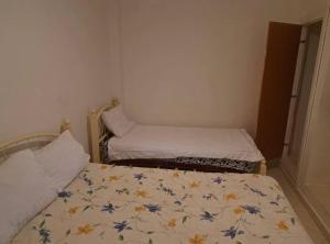 Habitación pequeña con 2 camas en una habitación en Apartment familiale oued laou, en Oued Laou
