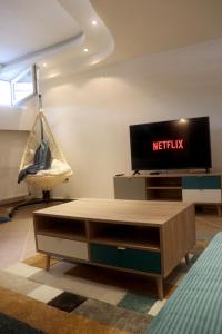 ノヴィサドにあるRenovated Apartment with Jacuzzi in Novi Sadのリビングルーム(テレビ、コーヒーテーブル付)