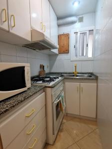 a kitchen with a microwave and a stove top oven at Habitación acogedora a 20min del centro, en Barcelona in Santa Coloma de Gramanet