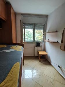 um quarto com uma cama, uma mesa e uma janela em Habitación acogedora a 20min del centro, en Barcelona em Santa Coloma de Gramanet