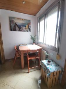 a table and chair in a room with a window at Habitación acogedora a 20min del centro, en Barcelona in Santa Coloma de Gramanet