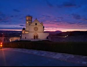 um edifício com uma torre de relógio em cima em LE DIMORE ARCANGELO Maria em Assisi
