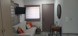 ein Wohnzimmer mit einem Sofa und einem TV in der Unterkunft ΣΤΟΥΝΤΙΟ ΕΥΑΓΓΕΛΙΑ in Nafpaktos