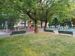 a park with green benches and a playground at Monolocale piano alto luminoso pochi minuti metro rossa Milano in Milan