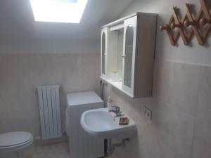 a bathroom with a sink and a toilet and a mirror at Monolocale piano alto luminoso pochi minuti metro rossa Milano in Milan