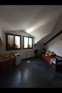 a bedroom with a bed and a table and windows at Monolocale piano alto luminoso pochi minuti metro rossa Milano in Milan