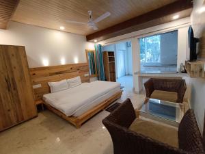 a bedroom with a bed and a table and chairs at Hill Hoppers Hotel in Rishīkesh