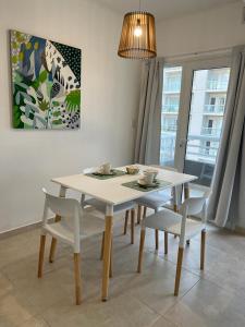 a white table and chairs in a dining room at Depto 1 dormitorio vista al mar!! in Puerto Madryn