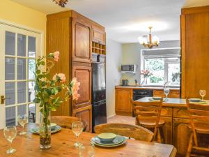 a kitchen with a table with a vase of flowers on it at Court House in Halsall