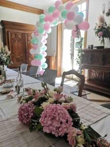 Ein Tisch mit Blumen und Ballons. in der Unterkunft Château d'Issandou in Golfech