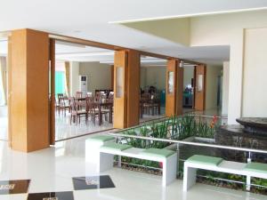 a lobby with green benches and a dining room at Ruan Rim Nam in Roi Et