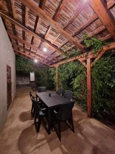 a black table and chairs under a wooden pergola at GOLD Apartman in Sanski most