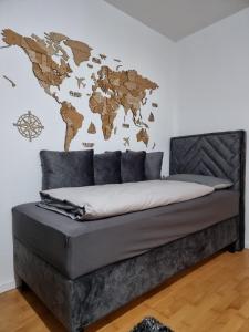 a bedroom with a bed with a world map on the wall at GOLD Apartman in Sanski most