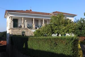 ein weißes Haus mit einer Hecke davor in der Unterkunft Refugio D Alecrim in Paredes