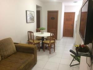 een woonkamer met een bank en een tafel en stoelen bij Residencial COLIBRI in Garopaba
