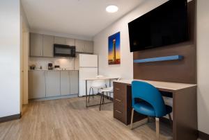 cocina y escritorio con silla azul en una habitación en Suburban Studios Biloxi North Area, en Biloxi