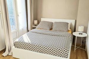 a bedroom with a bed with black and white sheets and a window at Appart Cosy & Spacieux-Métro7 Louis-Aragon+Parking in Vitry-sur-Seine
