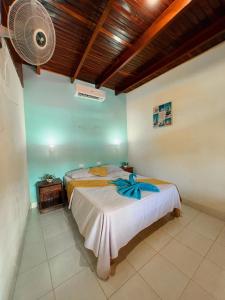 a bedroom with two beds and a fan at Hostel Samara in Sámara