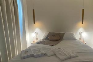 a bed with two towels and two lamps on it at Oikos Sani Suites in Sani Beach