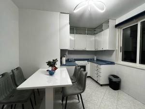 a kitchen with a white table and chairs in it at Apartment 7 in Izola +13 photos