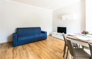 a living room with a blue couch and a table at Pet Friendly Apartment In Casalvelino in Casal Velino