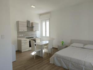 una camera da letto con un letto, un tavolo e una cucina di Alghero Experience ad Alghero