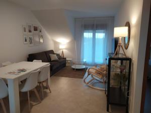 a living room with a table and a couch at ATICO A 3 KM DE SANXENXO CON PISCINA Y GARAJE in Sanxenxo