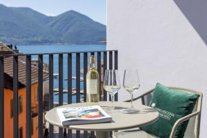 un tavolo con due bicchieri e una bottiglia di vino di Living Ascona Boutique Hotel - Smart Hotel ad Ascona