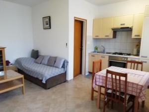 cocina y sala de estar con sofá y mesa en Apartmani Vesna, en Buje