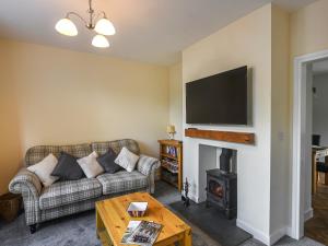 a living room with a couch and a fireplace at Pickle Cottage in Church Stretton