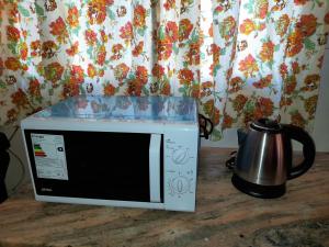 a microwave sitting on a table next to a coffee pot at Valentino Apart I in Jesús María