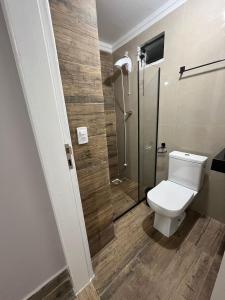 a bathroom with a toilet and a glass shower at Cobertura in Florianópolis