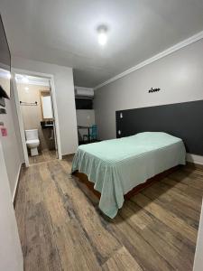 1 dormitorio con 1 cama con manta verde en Cobertura en Florianópolis