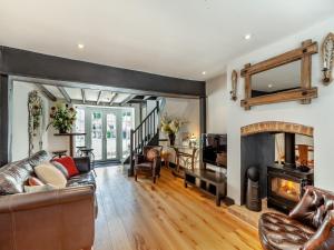a living room with a couch and a fireplace at Cutters Cottage in Roydon