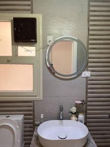La salle de bains est pourvue d'un lavabo et d'un miroir. dans l'établissement Cozy flat in boutique Complex, au Caire