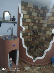 ein Bad mit einem Waschbecken und einer Dusche in der Unterkunft شفشاون in Aït Saïd