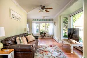 a living room with a brown leather couch and a flat screen tv at Beautiful fully-furnished Colonial in Millersville in Millersville